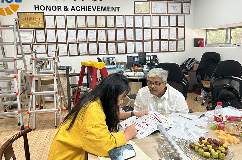 Indian customers and female engineers discuss ladder production equipment